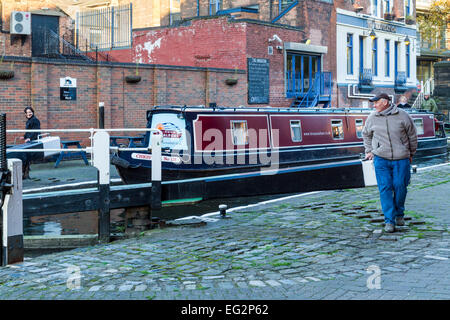 Mann und Frau Eröffnung Schleusentore auf dem Nottingham und Beeston Kanal mit der Navigation pub hinter sich. Nottingham, England, Großbritannien Stockfoto