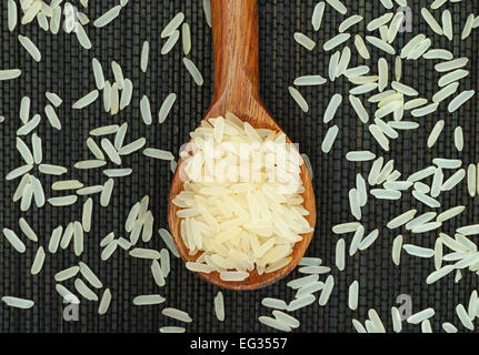 Parboiled-Reis in Holzlöffel auf schwarzen Serviette. Adobe RGB. Stockfoto