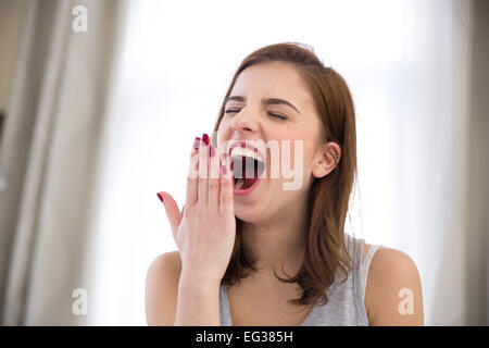 Junge schöne Frau Gähnen zu Hause Stockfoto
