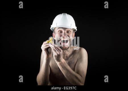 glücklich Bergmann zeigt einen golden nugget Stockfoto