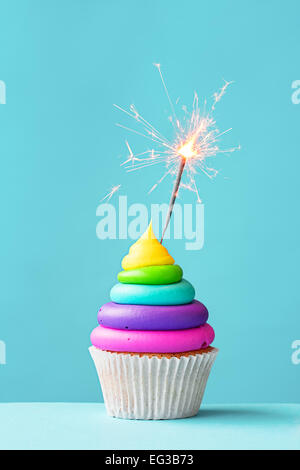 Bunte Kuchen verziert mit einer Wunderkerze Stockfoto