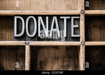 Das Wort "Spenden" in Vintage Metall Buchdruck Typ sitzt in einer Holzschublade geschrieben. Stockfoto