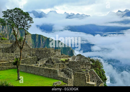 Niedrige Wolken über Berge, Steinbauten, Machu Picchu Inka-Ruinen in der Nähe von Aguas Calientes, aka Machu Picchu Pueblo, Cusco, Peru Stockfoto