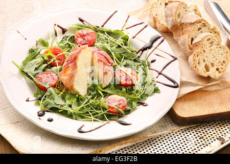 Mozzarella gebacken in Parma-Schinken mit Rucola Stockfoto