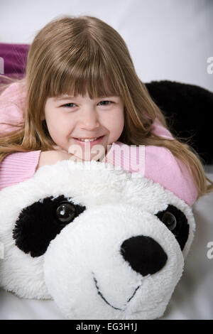 Fünf Jahre altes Mädchen mit einem riesigen, Stofftier Panda-Bären kuscheln Stockfoto