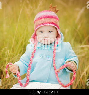 schöne Mädchen mit Down-Syndrom im Herbst Park sitzen Stockfoto