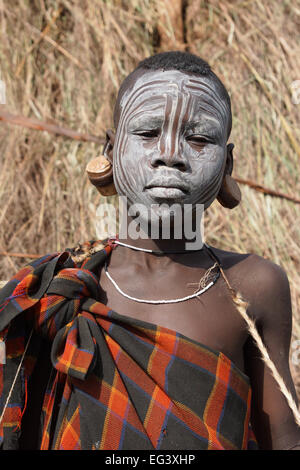 JINKA, Äthiopien - 21. November 2014: Young Mursi junge mit traditionellen Malerei am 21. November 2014 in Jinka, Äthiopien. Stockfoto