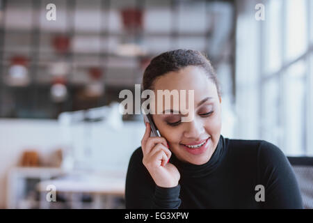 Nahaufnahme Bild der jungen Frau am Handy. African american weibliches Modell mit Handy bei der Arbeit. Stockfoto
