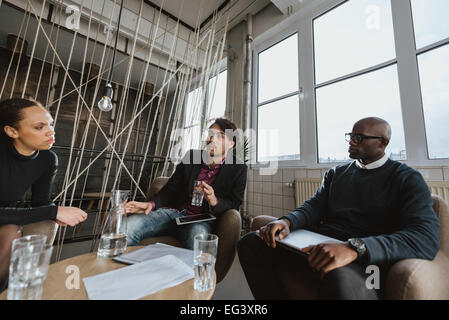 Gruppe von Multi ethnischen Führungskräfte diskutieren bei einem Treffen im Büro Lobby. Business-Leute-Brainstorming-Ideen. Stockfoto