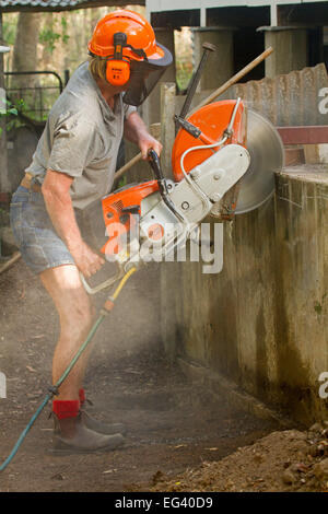 Mann Ohr & Auge Verschleißschutz Ziegel / Beton sah, um Betonwand im Rahmen des Baus zu schneiden / Sanierung Stockfoto