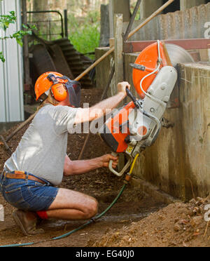 Mann Ohr & Auge Verschleißschutz Ziegel / Beton sah, um Betonwand im Rahmen des Baus zu schneiden / Sanierung Stockfoto