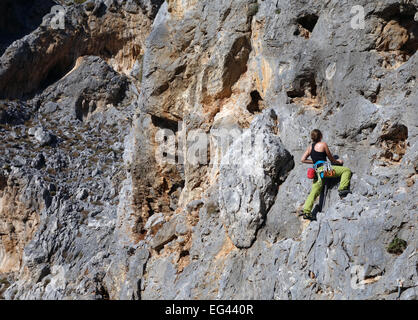 Weiblichen Rock Climber Klettern an steilen Felswand Stockfoto