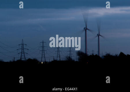 Windkraftanlagen und Elektrizität Masten nachts auf Romney Marsh, Kent, UK. Stockfoto