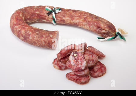 Ausgehärtete Chorizo mit einigen Stücke schneiden. Mit Hintergrund isoliert Stockfoto