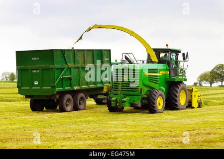 John Deere 7450 Propelled Forage Harvester und Bailey mechanische Silage Trailer. Stockfoto