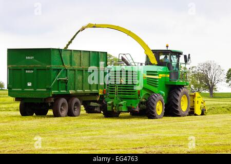 John Deere 7450 Propelled Forage Harvester und Bailey mechanische Silage Trailer. Stockfoto