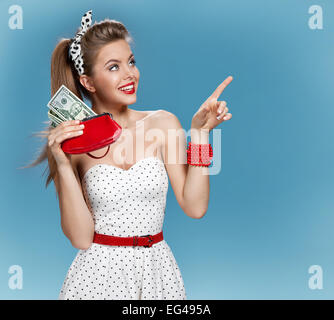 Attraktive junge Dame mit Bargeld und Shows Zeigefinger. -Shopping-Konzept Stockfoto