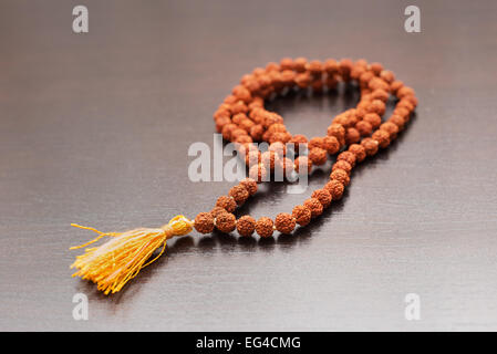 Japa Mala auf dem Tisch. Gebetskette aus den Samen des Baumes Rudraksha gemacht