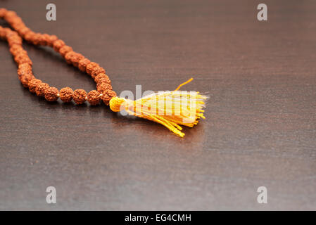 Japa Mala auf dem Tisch. Gebetskette aus den Samen des Baumes Rudraksha gemacht