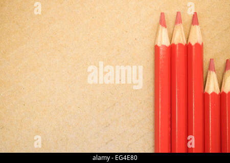 Satz von aufgereiht rote farbige Buntstifte hautnah auf leichten Karton Hintergrund Stockfoto