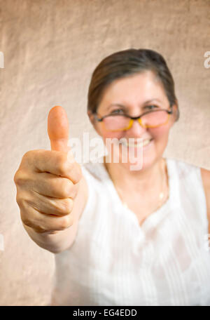 Glückliche Frau Daumen auftauchen. Zustimmung oder Billigung Konzept. Flachen DOF - Finger im Fokus. Stockfoto