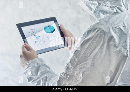 Chemischen Wissenschaftler in schützende Labor Kleidung verwenden digitale Tablet-Computer mit Chart und Infografiken angezeigt. Stockfoto