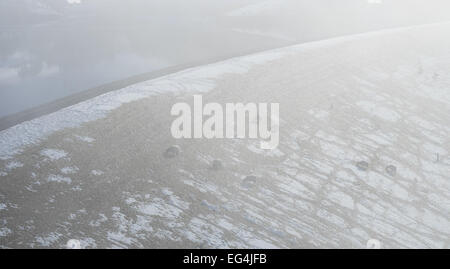 Schafe weiden in den Nebel und Schnee auf dem Damm, Kinder Reservoir im Peak District. Stockfoto