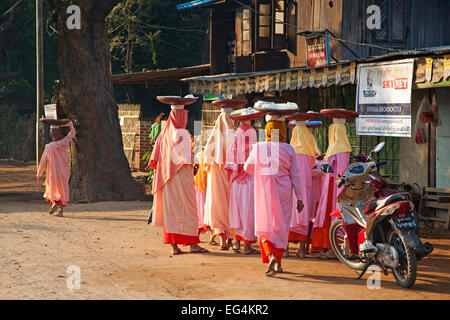 Burmesische weiblichen buddhistischen Nonnen gekleidet in rosa gehen Tür zu sammeln von Almosen Magway, Magwe-Region, Myanmar / Burma Stockfoto