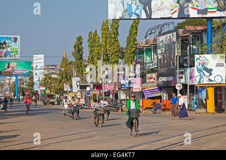 Radfahrer und Motorradfahrer in Einkaufsstraße in Pyay / Prome, Bago Region, Myanmar / Burma Stockfoto