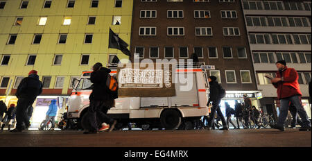 München, Deutschland. 16. Februar 2015. Demonstrator bei einer Demonstration unter dem Motto "für eine offene und geeinte Gesellschaft" gegen die Anti-Islamischen Bagida (Bayern gegen die Islamisierung des Abendlandes) Bewegung Spaziergang vorbei an einem Fahrzeug die Bären ein Banner lesen "Stop rassistischen Agitation" in München, Deutschland, 16. Februar 2015 gerichtet. Foto: TOBIAS HASE/Dpa/Alamy Live News Stockfoto