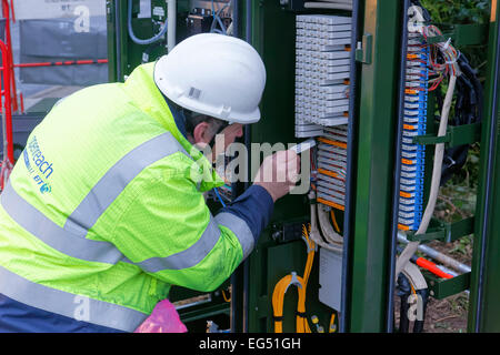 BT-Service-Ingenieur arbeitet an einer Breitband-Internet-Faser Kabinett auf der Straße Stockfoto