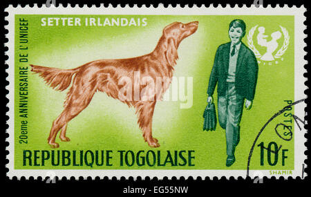 TOGO - CIRCA 1967: Eine Briefmarke gedruckt von Togo, zeigt den 20. Jahrestag von UNICEF und Irish Red Setter, ca. 1967 Stockfoto