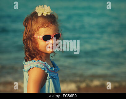 Schönes glückliches Kind Mädchen in Gläsern Meer Hintergrund auf. Vintage Porträt