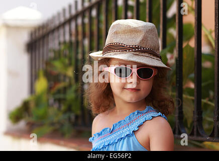 Mode Kind Mädchen mit Brille und Hut im freien Hintergrund. Closeup Stockfoto