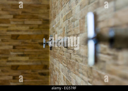 Der Wasserhahn auf dem Ziegel Wand Hintergrund (Wählen Sie Schwerpunkt) Stockfoto