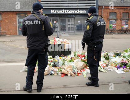 Kopenhagen, Dänemark. 17. Februar 2015. Polizisten stehen vor platzierten Blumen nach einem Terroranschlag im Krudttonden Café in Kopenhagen, Dänemark, 17. Februar 2015. Foto: Britta Pedersen/Dpa/Dpa/Alamy Live News Stockfoto