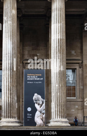 Die Fassade des British Museum, London, mit einem Poster für eine Ausstellung über klassische griechische Kunst - 'Defining Beauty - the Body in Old Greek Art' Stockfoto