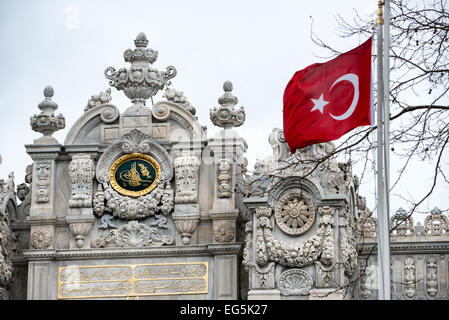 ISTANBUL, Türkei / Türkiye — vor dem Haupttor des Dolmabahcoc-Palastes fliegt Eine türkische Flagge. Der Dolmabahce-Palast am Ufer der Bosporus-Straße war von 1856 bis 1887 und von 1909 bis 1922 das Verwaltungszentrum des Osmanischen Reiches. Erbaut und dekoriert im osmanischen Barock-Stil, erstreckt sich das Gebäude entlang eines Abschnitts der europäischen Küste des Bosporus im Zentrum von Istanbul. Stockfoto