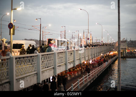 ISTANBUL, Türkei / Türkiye — Fischer säumen den Rand der Galata-Brücke mit ihren Linien über die Seite zum Goldenen Horn. Die Galata-Brücke, die das Goldene Horn überspannt und Eminonu mit Karakoy verbindet, ist eine zweistöckige Brücke, die Straßen-, Straßenbahn- und Fußgängerverkehr auf der obersten Ebene mit Restaurants und Bars auf der darunter liegenden Ebene abwickelt. Stockfoto