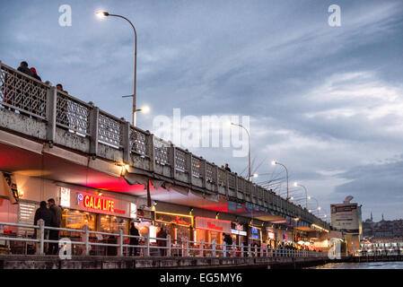 ISTANBUL, Türkei / Türkiye — die Galata-Brücke, die das Goldene Horn überspannt und Eminonu mit Karakoy verbindet, ist eine zweistöckige Brücke, die Straßen-, Straßenbahn- und Fußgängerverkehr auf der obersten Ebene mit Restaurants und Bars auf der darunter liegenden Ebene abwickelt. Stockfoto