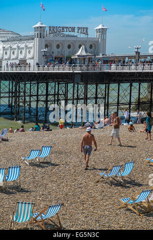 BRIGHTON, UK - 28. Juli 2013: Menschen genießen einen seltenen sonnigen Tag am Strand vor dem berühmten Pier von Brighton am 28. Juli 2013. Stockfoto