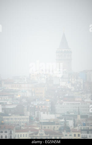 ISTANBUL, Türkei / Türkiye – die Silhouette des Galata-Turms taucht durch schweren Nebel auf, vom Topkapi-Palast aus gesehen. Diese stimmungsvolle Szene fängt den historischen Turm ein, ein Wahrzeichen des Istanbuler Stadtteils Beyoğlu, kaum sichtbar über dem Goldenen Horn vom Aussichtspunkt der ehemaligen osmanischen Kaiserresidenz. Stockfoto