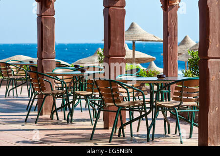 Tische und Stühle in der Nähe von dem Meeresstrand Stockfoto