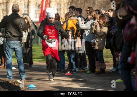 London, UK. 17. Februar 2015.   M/s, Lords und Mitglieder der parlamentarischen Pressetribüne nehmen Teil in der jährlichen, Nächstenliebe parlamentarischen Pancake Race in Victoria Tower Gardens, neben den Houses of Parliament am Faschingsdienstag.  Im Bild: Robbie Gibb, BBC täglich und Sonntag Politik nimmt Teil in das Rennen. Bildnachweis: Stephen Chung/Alamy Live-Nachrichten Stockfoto