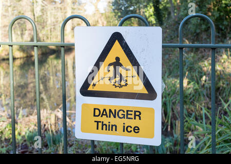 Gefahr dünnem Eis Warnschild am schmiedeeisernen Zaun Ententeich Stockfoto