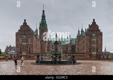 Touristen besuchen das Schloss Frederiksborg und die barocken Gärten bei Regenwetter. Stockfoto