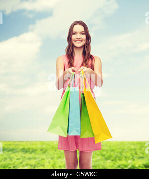lächelnde Frau im Kleid mit vielen Einkaufstüten Stockfoto