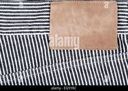 Leere Leder-Jeans-Label auf einem gestreiften Jeans genäht Stockfoto