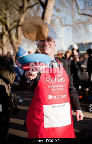 Ben Wright, BBC, klappt einen Pfannkuchen vor der Abgeordneten, parlamentarischen Pancake Race-2015. Stockfoto