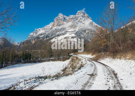 Snowy Track mit Reifenspuren in Richtung schneebedeckten Berg, Sinsat, Ariège, Französischen Pyrenäen, Frankreich Stockfoto